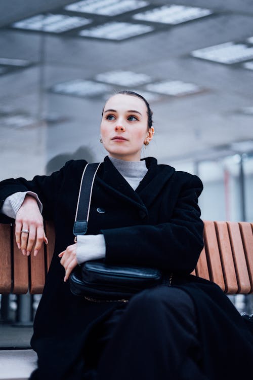 Woman in a Coat Sitting on a Bench 