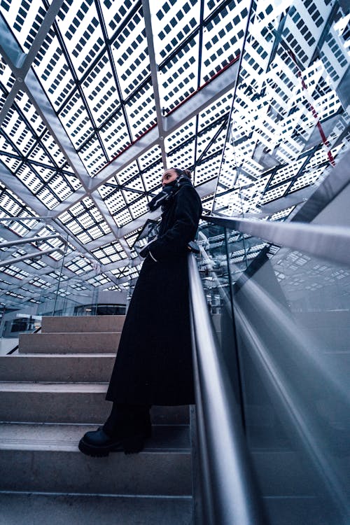 Low Angle View of a Woman Standing and Leaning on the Stairs