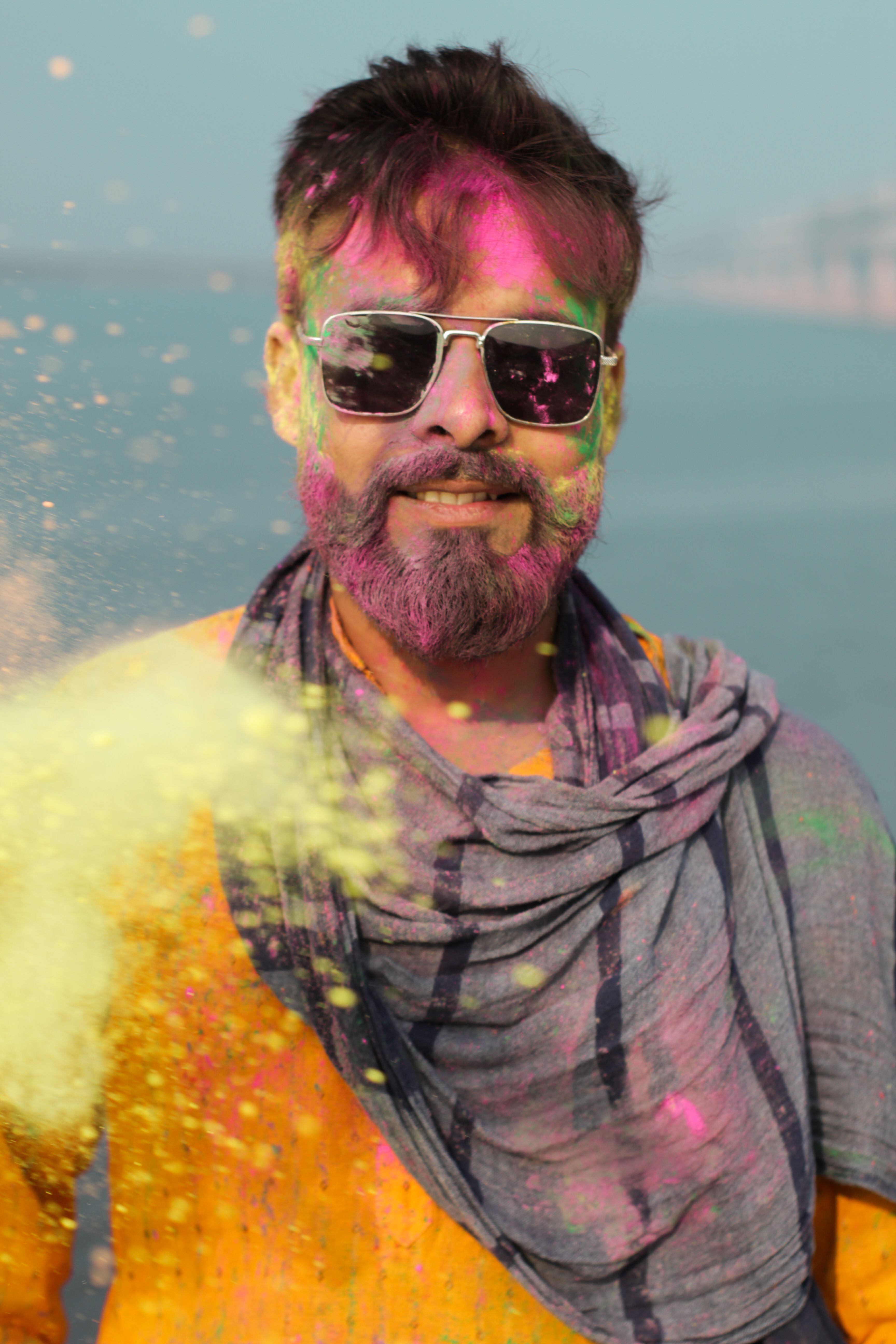 A joyful man with colored powders on his face celebrates Holi festival in Patna, India.