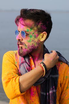 Colorful portrait of a man joyfully celebrating Holi with vibrant powders in Patna, India.