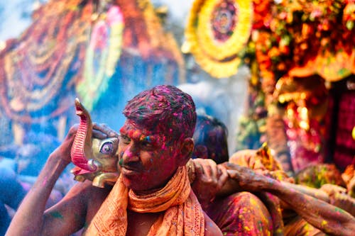 Man Carrying a Parade Float at the Hindu Festival of Colors