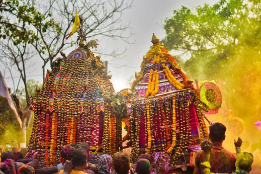 Colorful festival in Odisha with decorated rath chariots and vibrant powder.