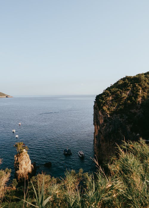 Boats Anchored in the Shadow of a Cliff