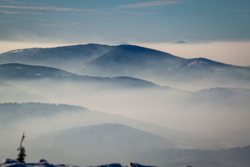 Free A tranquil mountain landscape enveloped in fog and mist, creating a serene atmosphere. Stock Photo