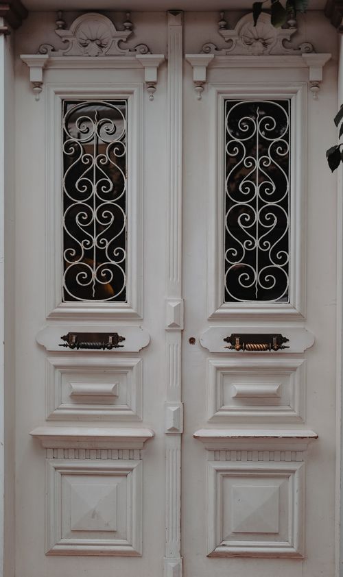 Free Close-up of elegant white doors with intricate ironwork, perfect for elegant architectural themes. Stock Photo