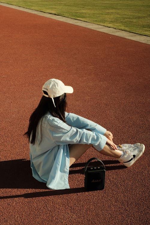 Woman Sitting on a Running Track 