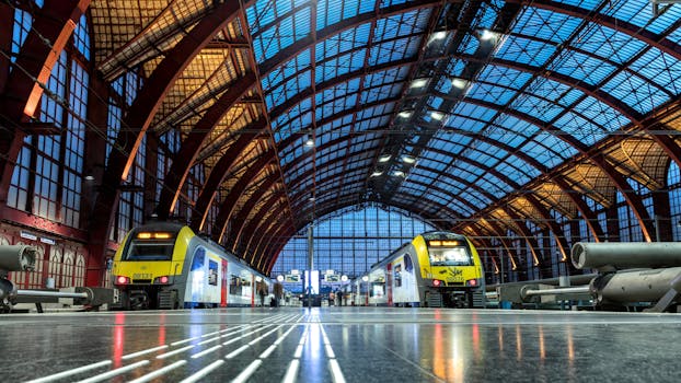 Interior view of Antwerp Central Station showcasing modern trains and stunning architecture.