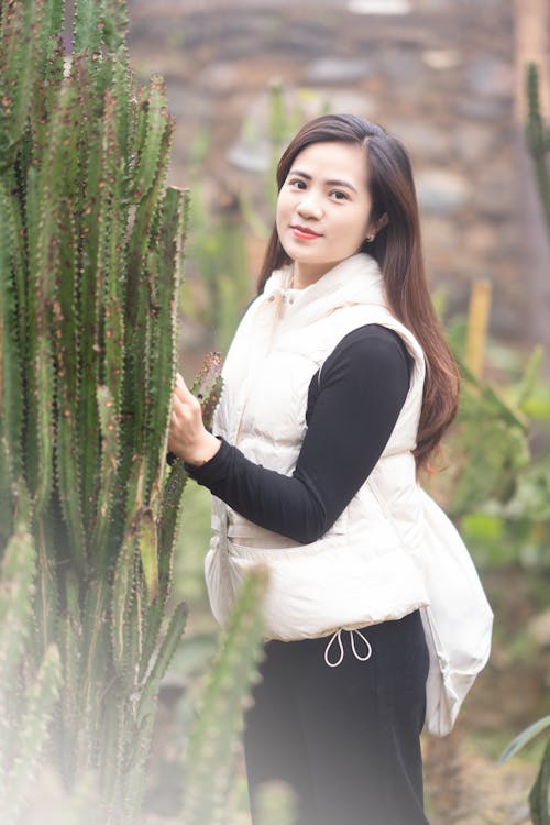 Free Pretty Brunette Posing in Front of Cacti Stock Photo