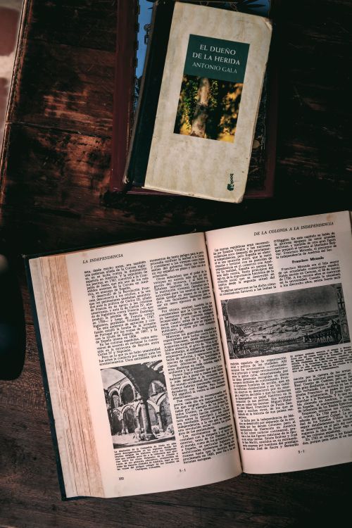 Free Open book on a wooden table, showcasing classic literature and images. Stock Photo