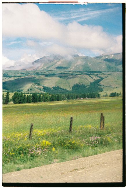 Beautiful rolling hills and mountains under a cloudy sky in a rural setting.