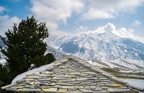 Winter Landscape with Mountains and a Stone Roof in the Foreground