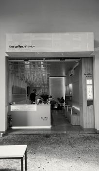 Monochrome view of a trendy urban café entrance with modern interior design.