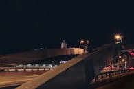 晚上，一名男子坐在城市一座灯火通明的桥上