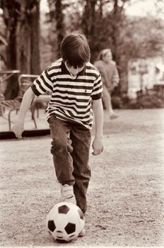 A young boy practicing soccer skills outdoors in Mons, Belgium.