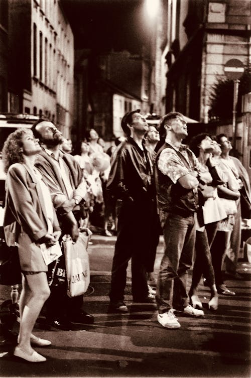 Sepia Photo of a Crowd of People Standing in the Street and Looking Up