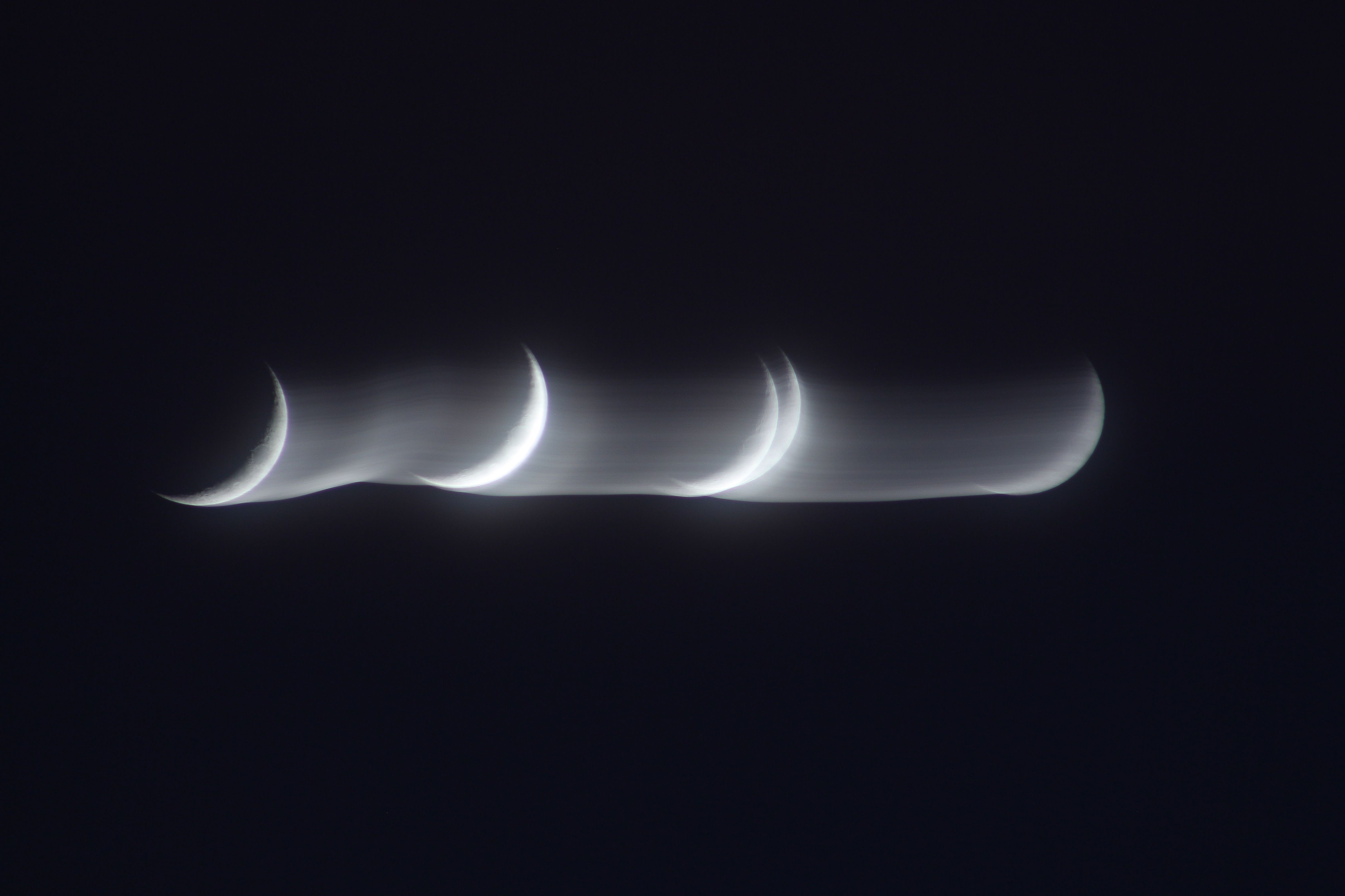 Artistic capture of multiple crescent moon phases with a blurred motion effect at night.
