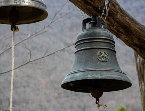 Close-up of Retro Iron Bell Hanging on Wood Bar
