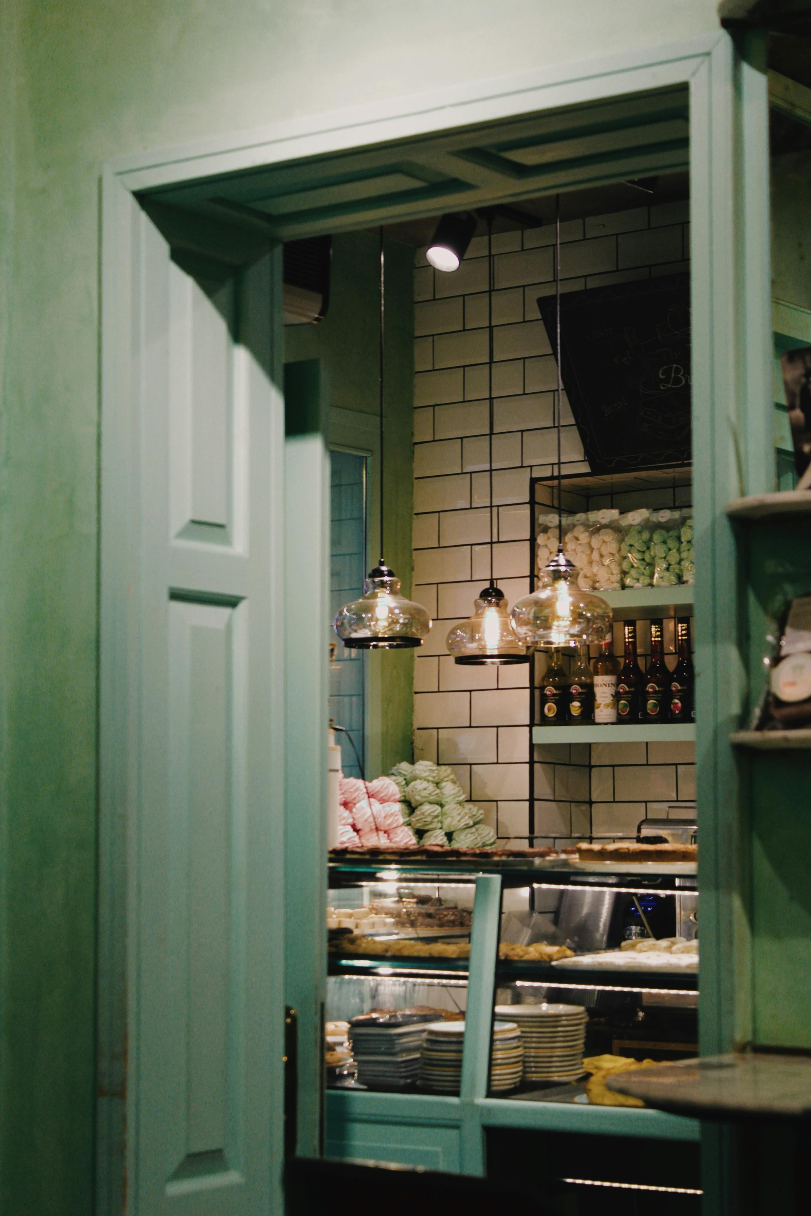 An inviting bakery interior with pastel doors and decorative lighting.