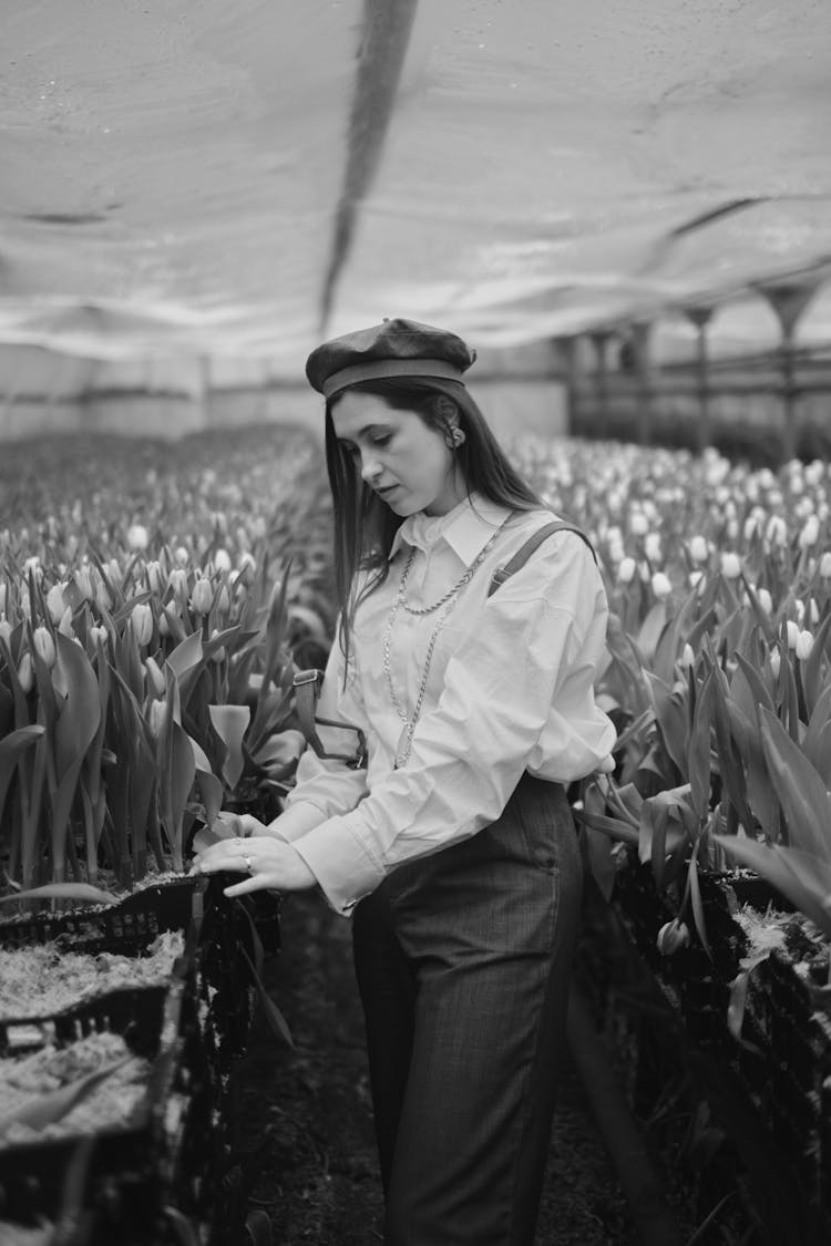 Black And White Photo Of A Woman In A Greenhouse 