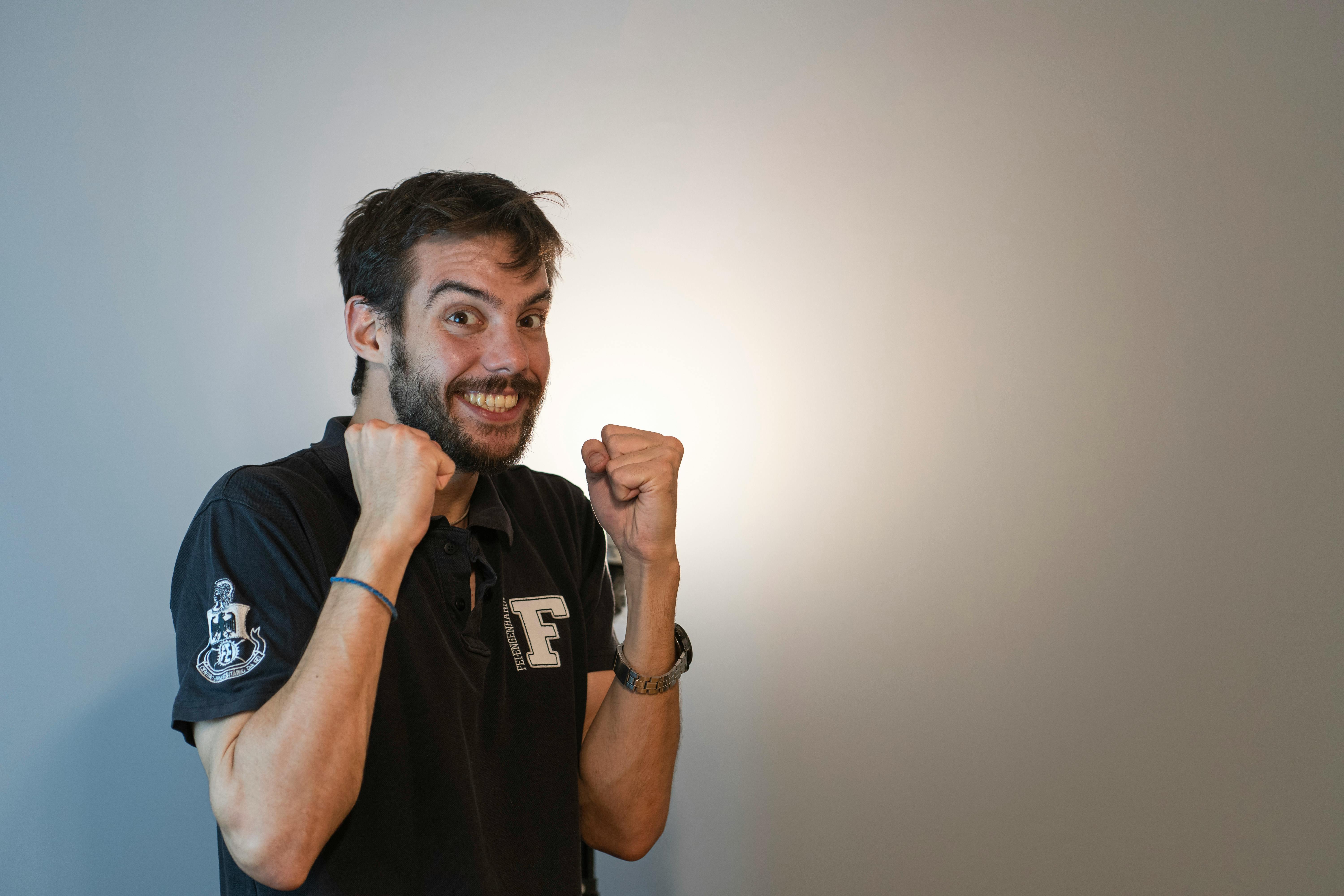 a man in a black shirt is holding his fist up