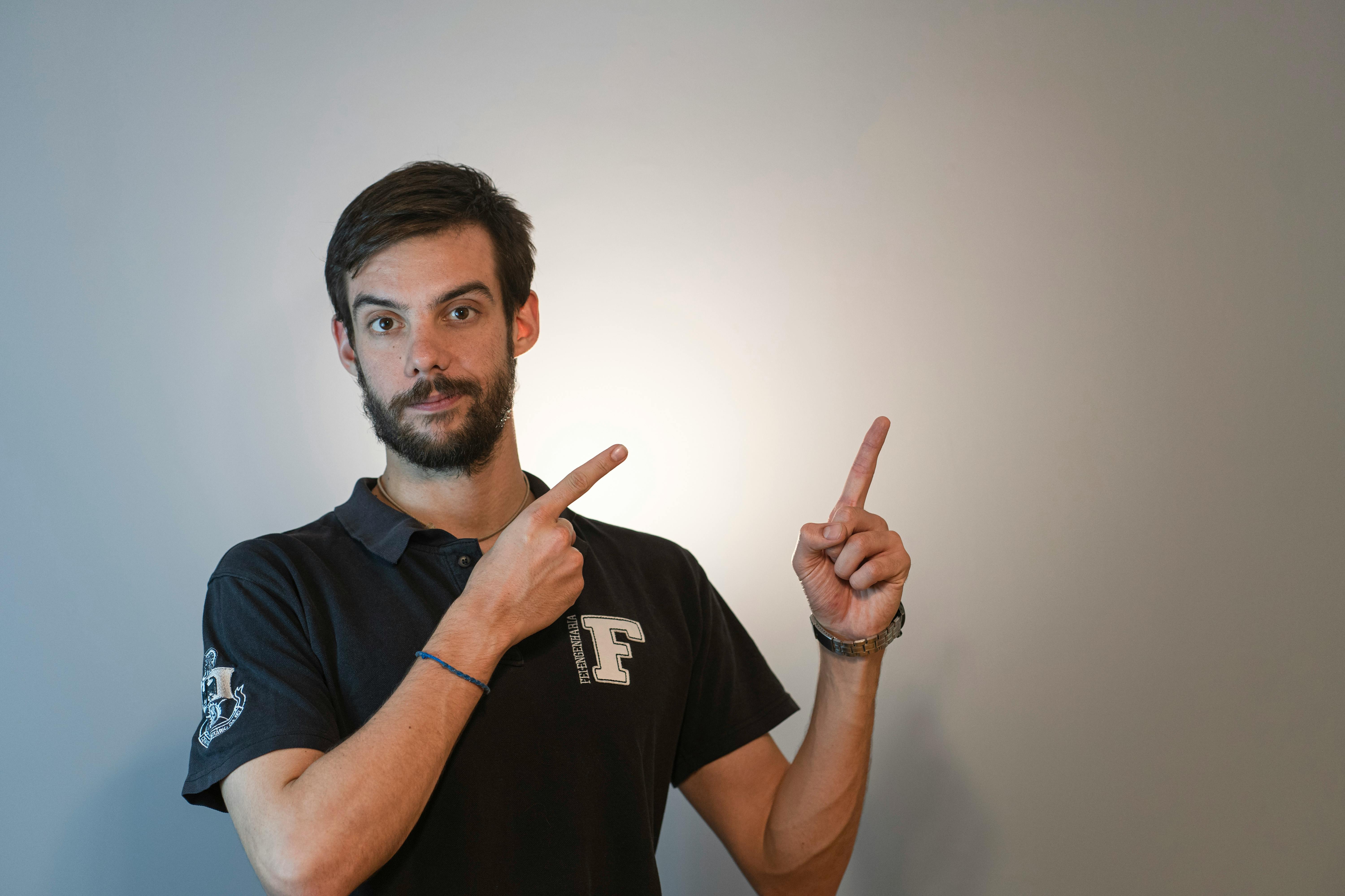 a man in a black shirt pointing at something