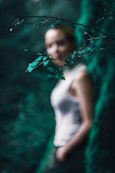 模糊的户外女性肖像以树枝为重点，营造出艺术构图