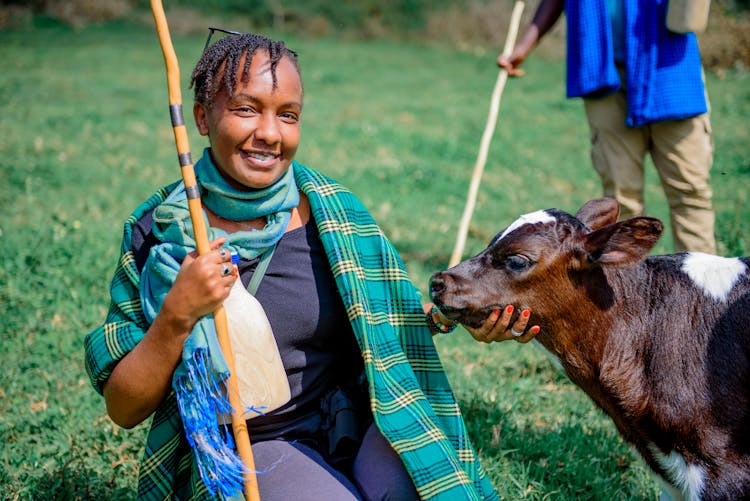 Smiling Woman Posing With Cow Calf