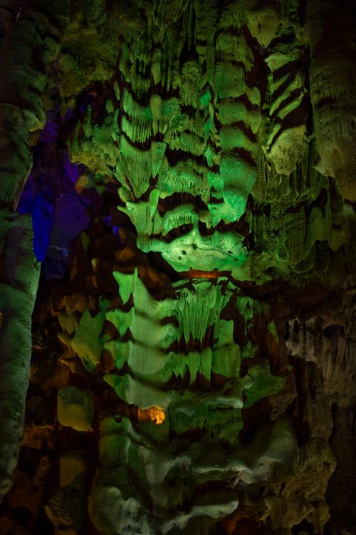 Free Intricate cave formations illuminated with green and blue lighting, creating a mystical ambiance. Stock Photo