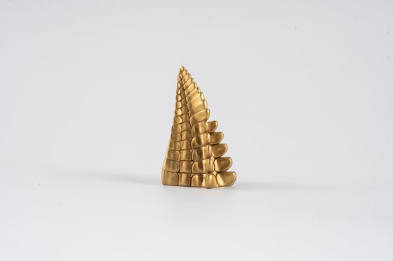 Gilded spiral object on a pale backdrop, photo by Coppertist Wu on Pexels