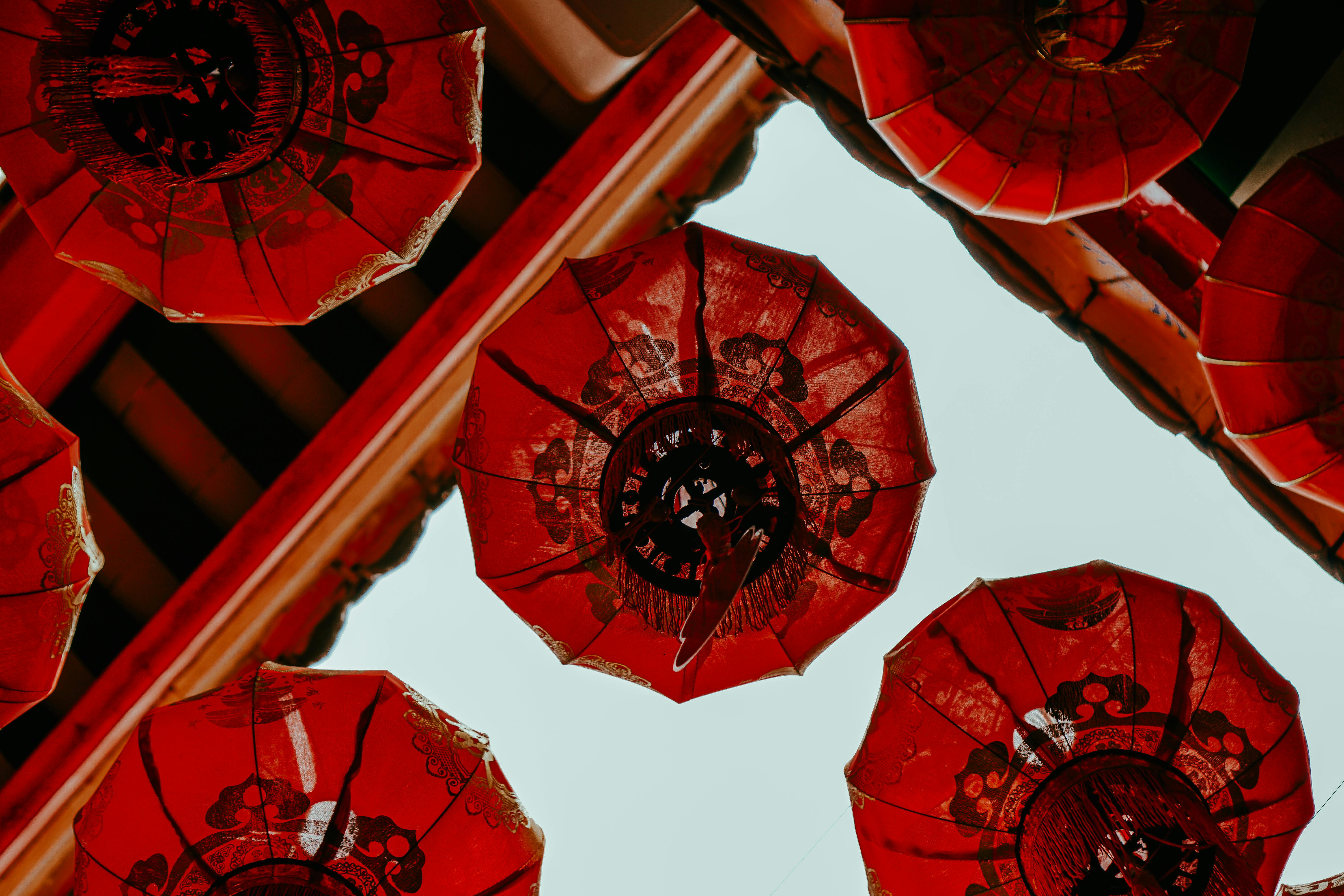 Red lanterns creating a striking contrast against a blue sky, viewed from below.