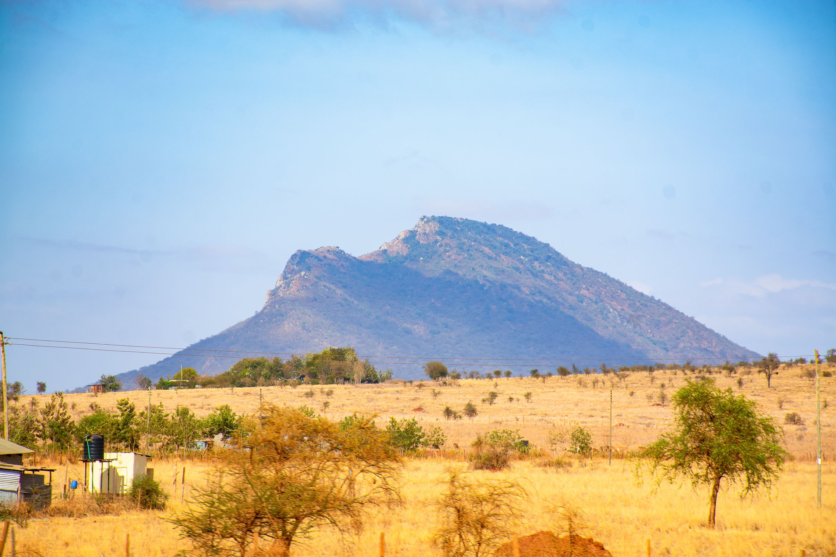 Beautiful view of mountains and savannah landscape in Kajiado, Kenya, under a clear blue sky.