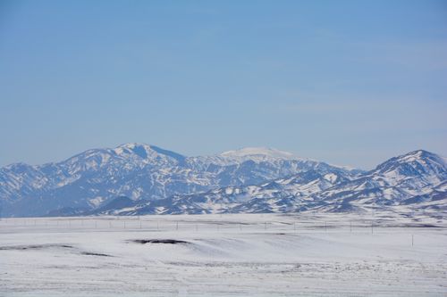 Free Breathtaking view of snow-covered mountains in Kazakhstan under a clear blue sky. Stock Photo
