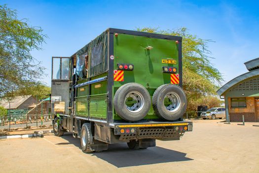 A sunlit safari truck parked outdoors in Namanga, Kenya, with clear blue sky.