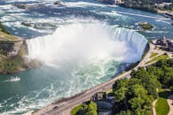 在阳光明媚的夏日，乘船游览尼亚加拉大瀑布，郁郁葱葱的绿色植物和令人惊叹的空中拍摄令人赞叹