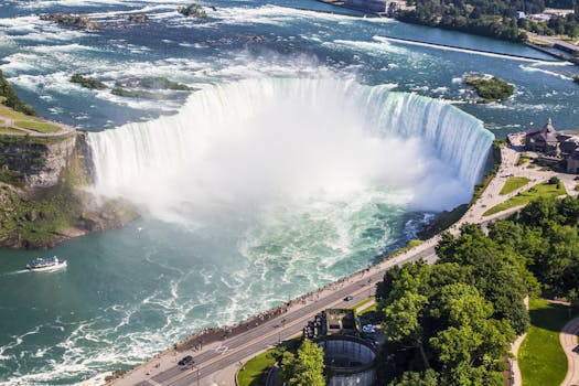 Stunning aerial shot of Niagara Falls with a boat tour and lush greenery on a sunny summer day. by Pixabay