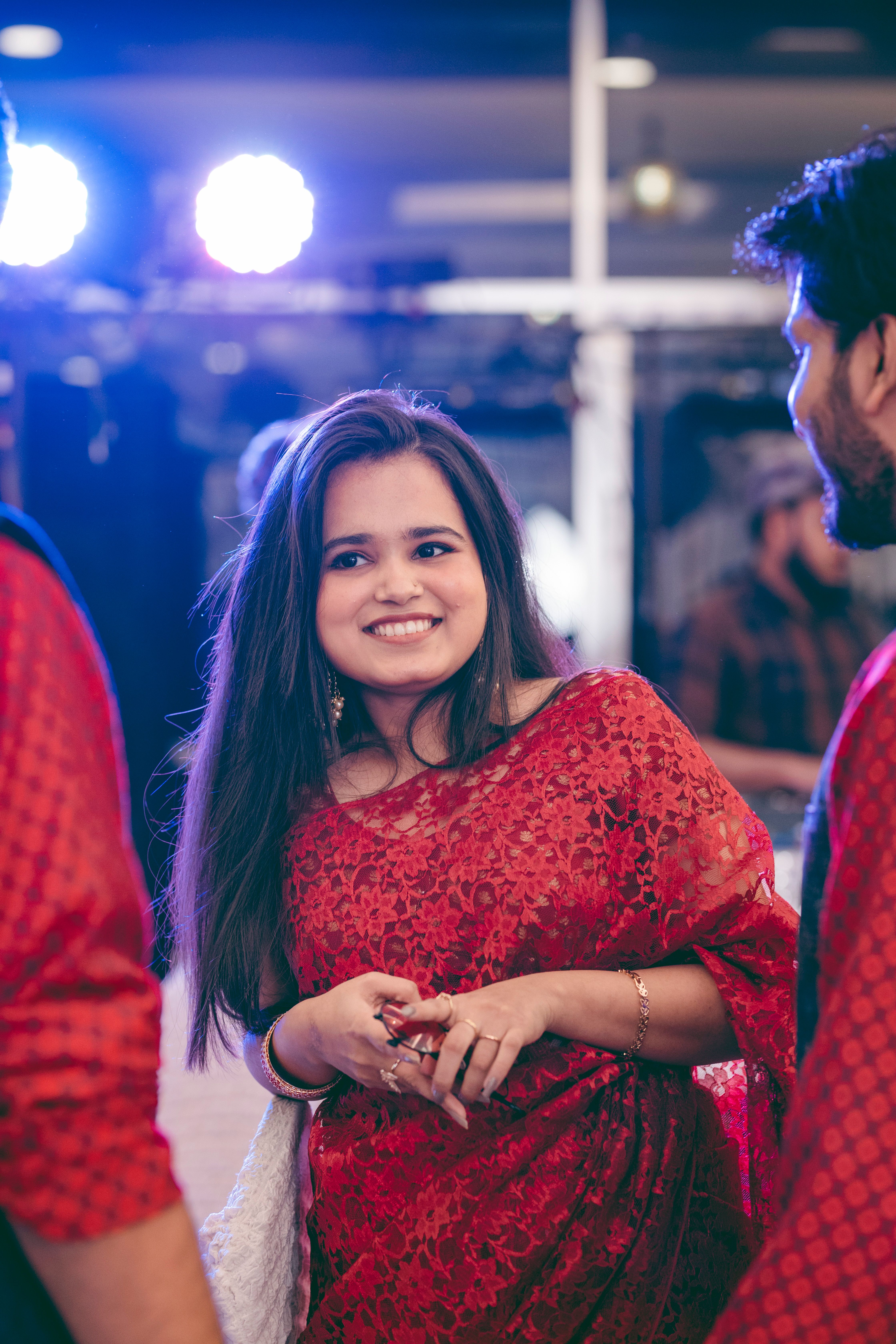 Joyful moment at a celebration with a woman in a stunning red saree, capturing happiness and tradition.