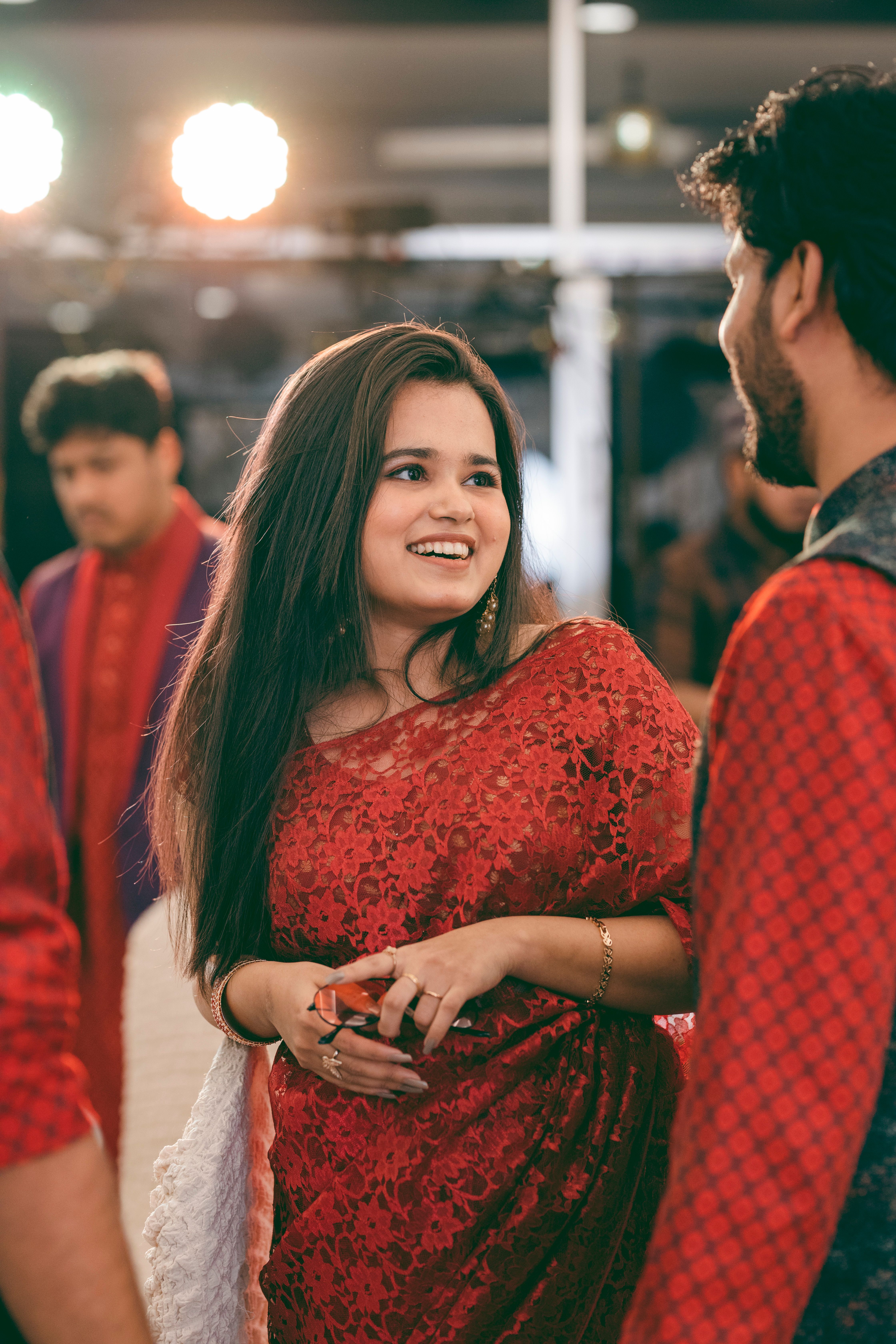 Smiling people enjoying a celebration in traditional South Asian attire, highlighting cultural festivity.