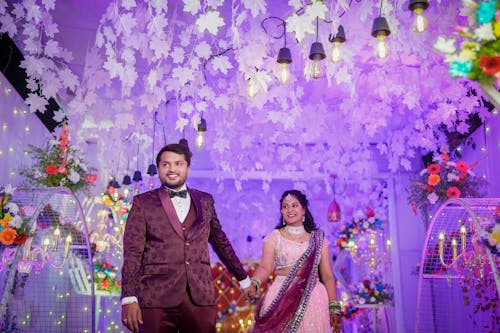 Bride and Groom in Traditional Clothing Walking into the Wedding Reception Holding Hands