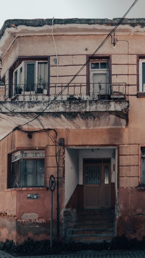 Free A rustic urban building facade with balconies and entrances, showcasing traditional architecture. Stock Photo