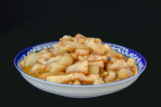 A flavorful Chinese stir fry served in a traditional blue patterned bowl.
