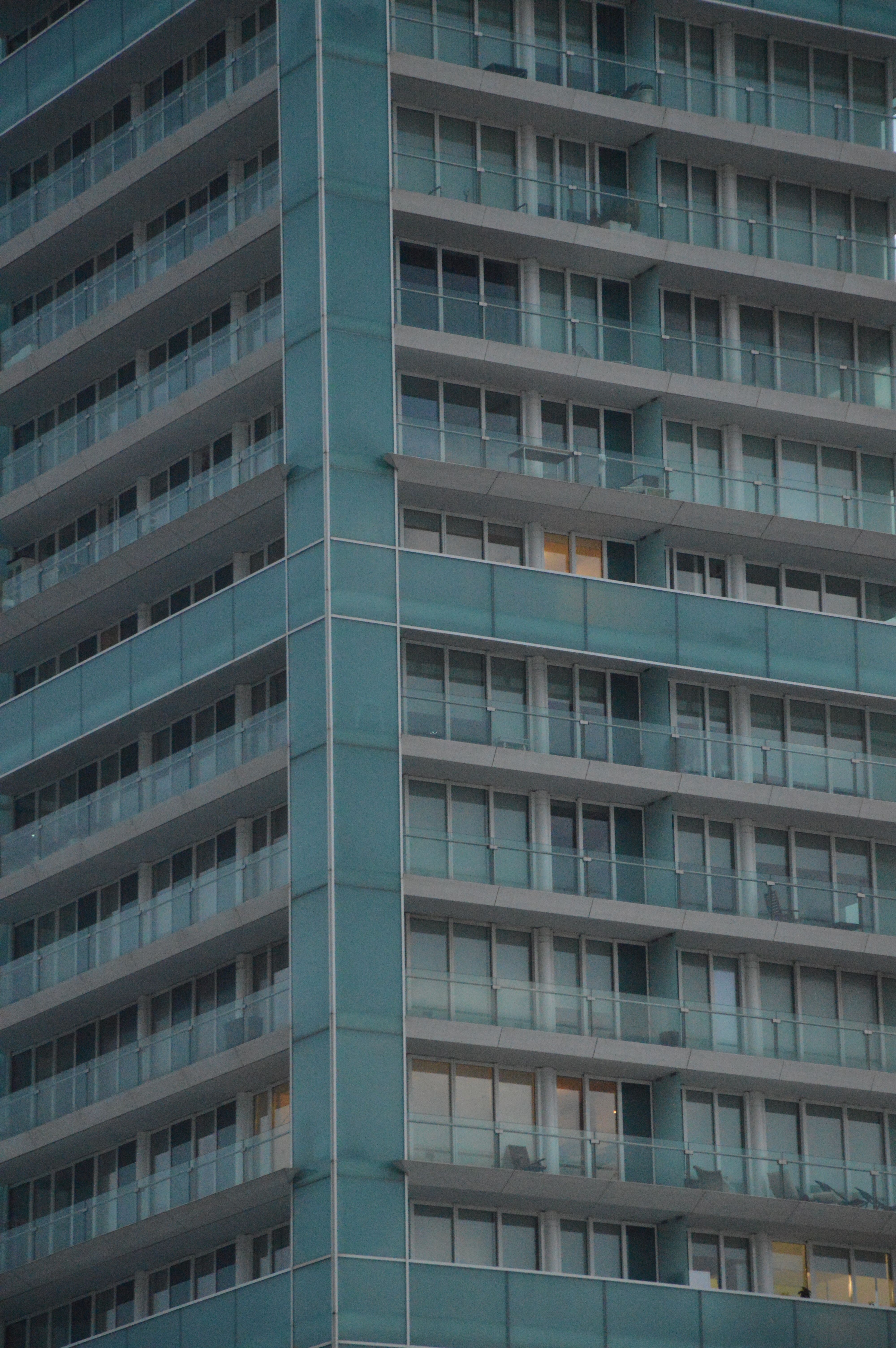 Close-up view of a modern residential skyscraper with balconies in an urban setting.