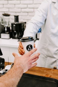 Customer receives a coffee cup from barista in a Baku coffee shop.