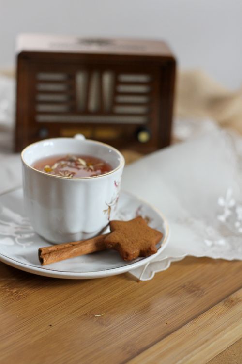 Free A cozy still life featuring tea with a biscuit and cinnamon stick on a saucer. Stock Photo