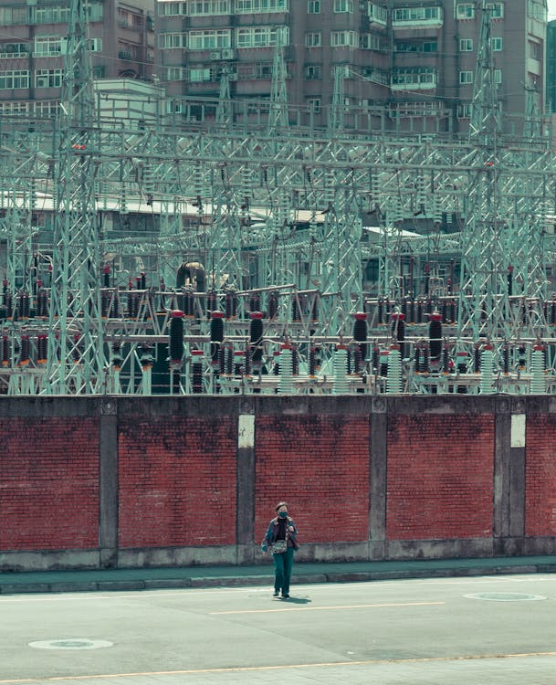 Man Standing on City Street in Industrial District