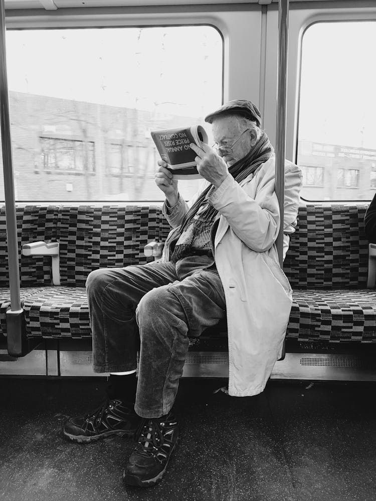 Man Reading Newspaper In Subway