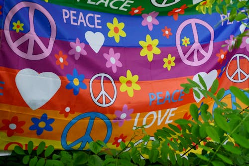 Close-up of a Rainbow Flag with Peace Signs and Flowers