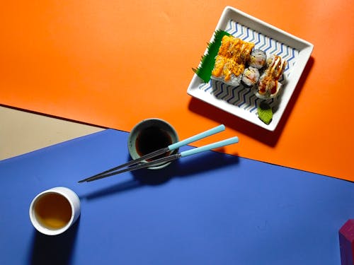 Sauces, Chopsticks and Sushi Rolls on Plate
