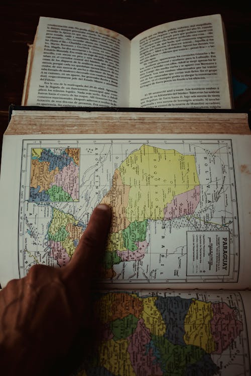 A person pointing at a map on a book