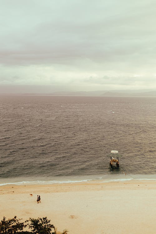 Photo of a Sea Beach against a Cloudy Sky 