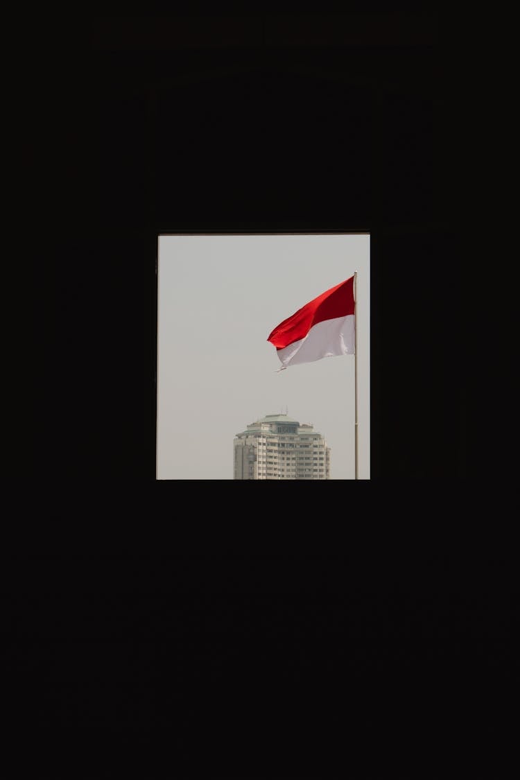 Window VIew Of A City Building And A Flag Of Indonesia 